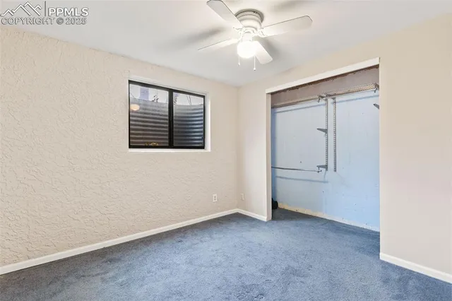 an empty room with a ceiling fan and a window