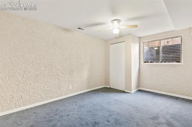 an empty room with a ceiling fan and a window
