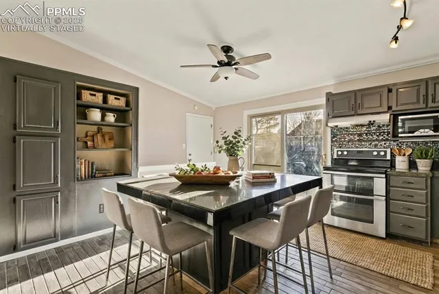 a kitchen with stainless steel appliances kitchen island granite countertop a dining table and chairs