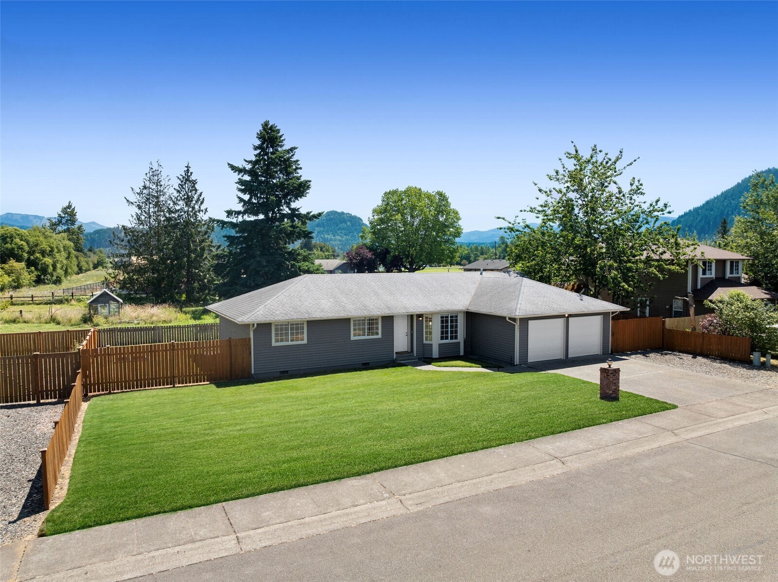 201 Schmid Street Enumclaw, WA 98022 - Photo 2 of 40 a white house with a big yard plants and large trees
