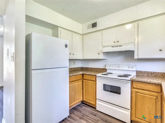 a white refrigerator freezer sitting inside of a kitchen