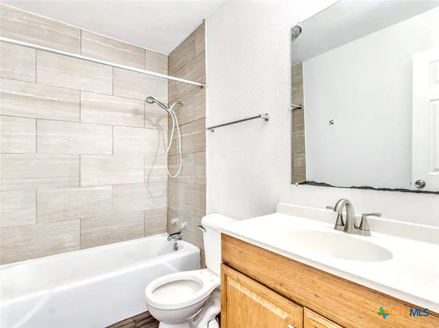 a bathroom with a granite countertop sink toilet bathtub and shower
