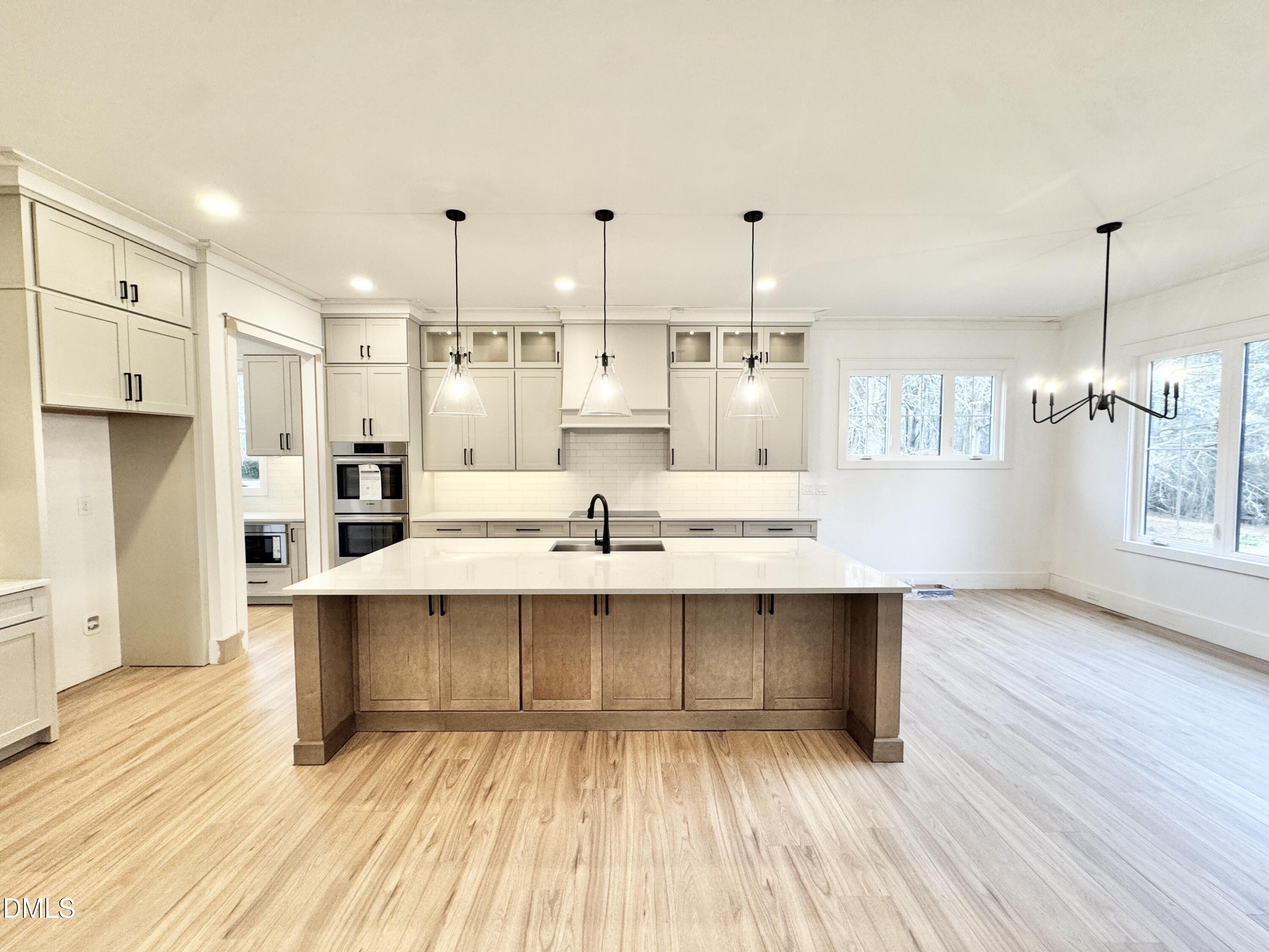 8012 Penny Road Raleigh, NC 27606 - Photo 18 of 83 a large white kitchen with wooden floor and a window