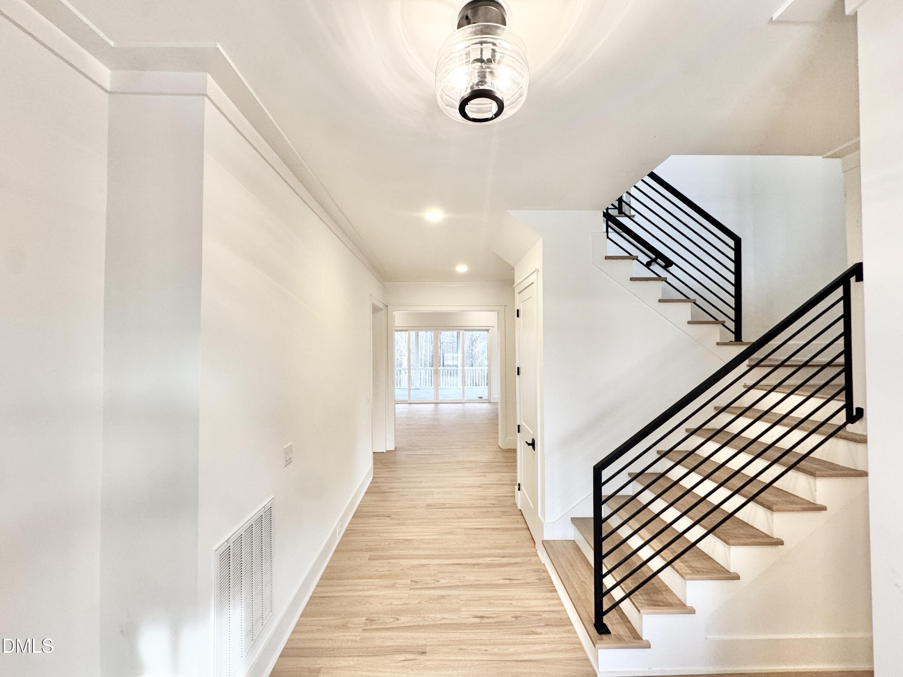 8012 Penny Road Raleigh, NC 27606 - Photo 2 of 83 a view of a hallway with wooden floor and staircase