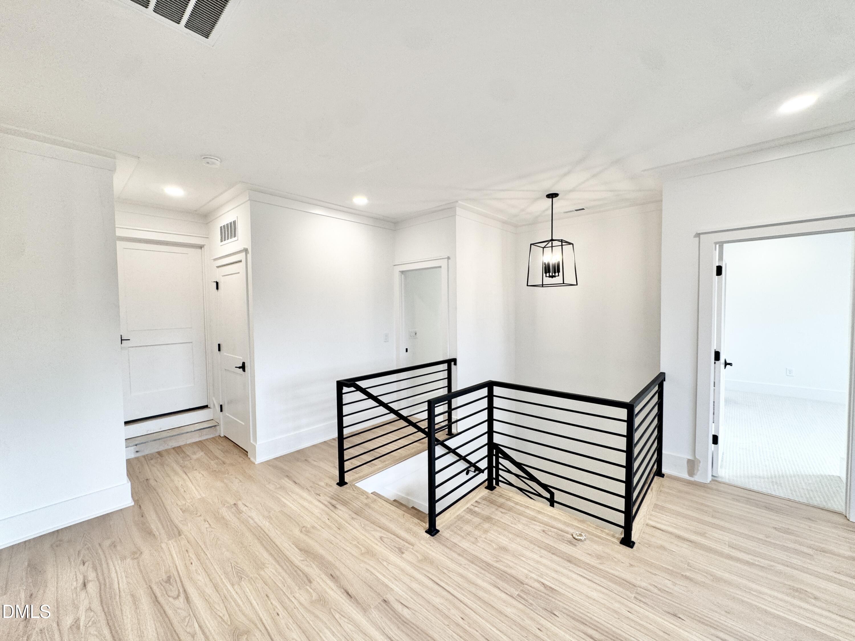 8012 Penny Road Raleigh, NC 27606 - Photo 57 of 83 a view of a hallway with wooden floor and staircase