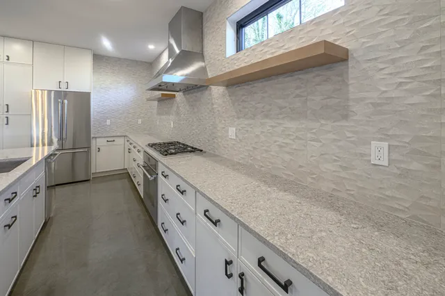 a kitchen with stainless steel appliances granite countertop a sink and a stove