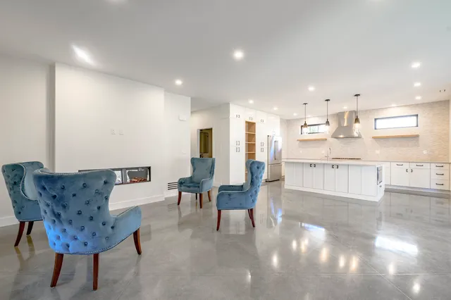 a living room with furniture and a dining table with kitchen view