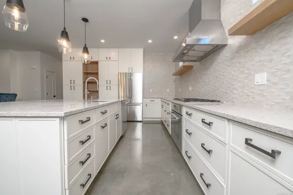 a large white kitchen with cabinets and a large window