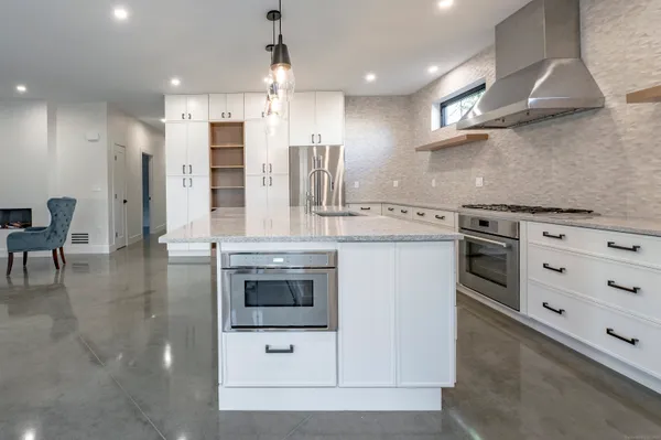 a kitchen with stainless steel appliances granite countertop a stove a sink and a refrigerator