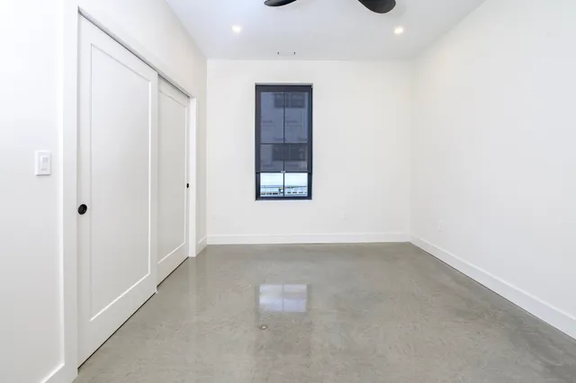 an empty room with a windows and closet