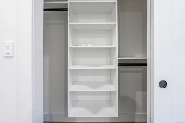 a view of a walk in closet with empty racks