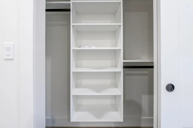 a view of a walk in closet with empty racks