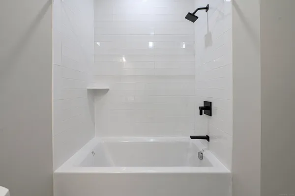 a white bath tub sitting next to a white sink and vanity