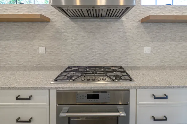a stove top oven sitting inside of a kitchen