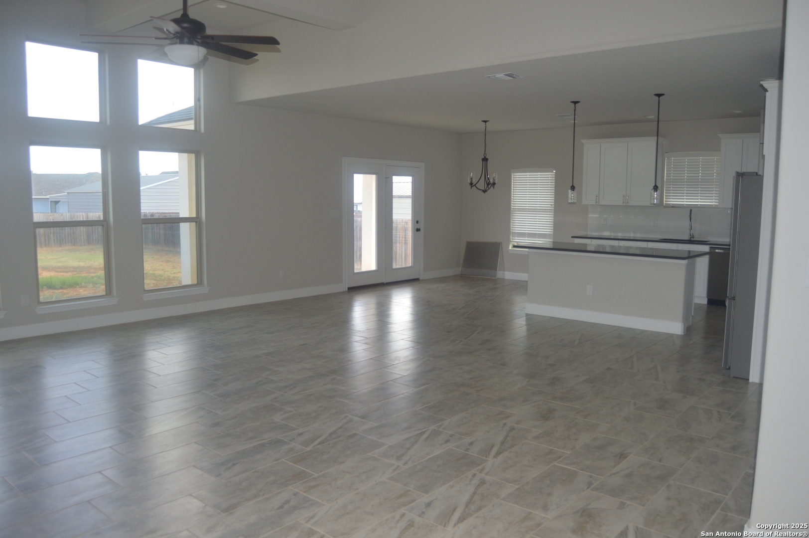 153 West Medium Meadow Drive Lytle, TX 78052 - Photo 10 of 26 an empty room with wooden floor and windows