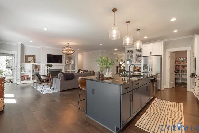 a living room with furniture kitchen view and a chandelier