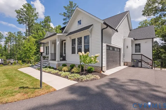 a front view of a house with a yard and potted plants