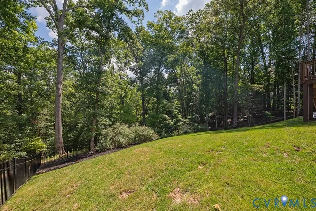a view of a big house with a big yard and large trees