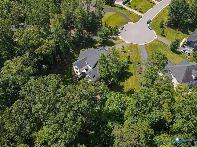 an aerial view of residential house with space and trees all around