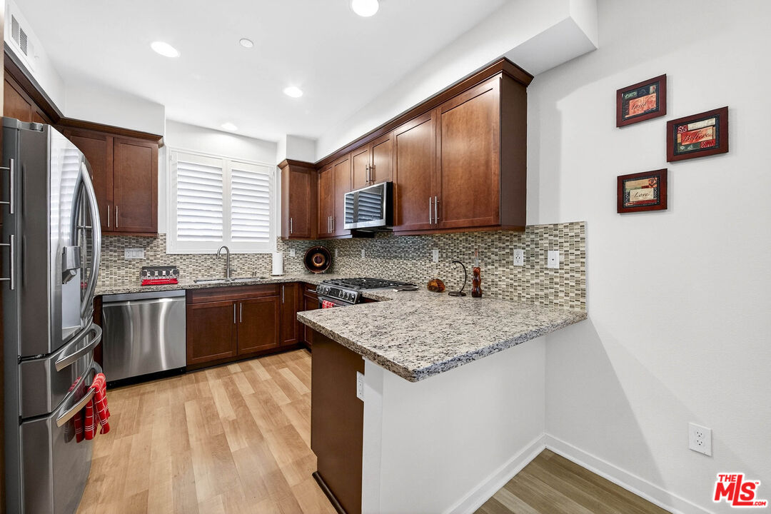 707 Colorado Circle Carson, CA 90745 - Photo 5 of 40 a kitchen with stainless steel appliances granite countertop a sink stove and refrigerator