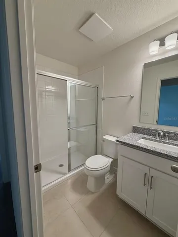 a bathroom with a granite countertop sink toilet and shower