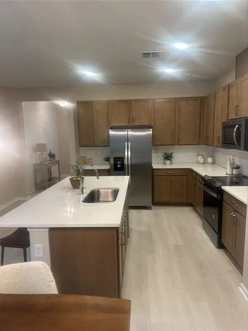 a kitchen with kitchen island sink refrigerator and cabinets
