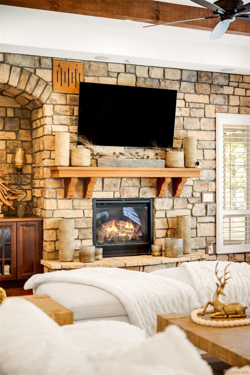 981 Buffalo Ridge Road Castle Pines, CO 80108 - Photo 13 of 49 a living room with fireplace furniture and a flat screen tv