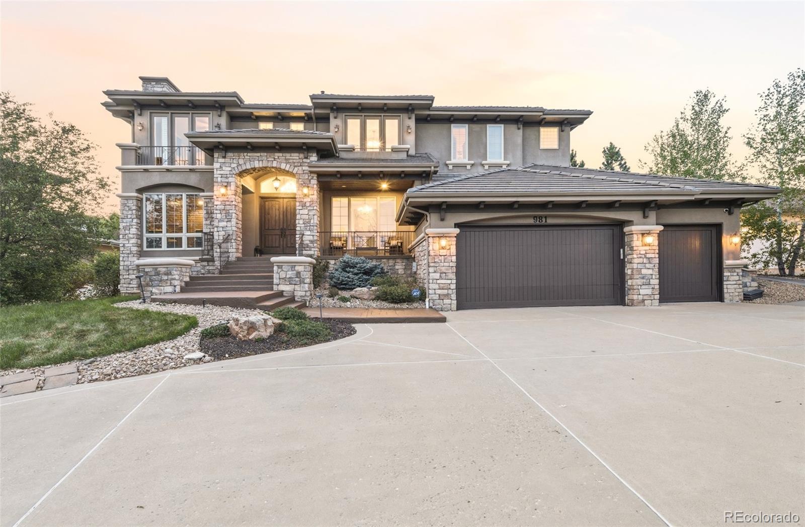 981 Buffalo Ridge Road Castle Pines, CO 80108 - Photo 2 of 49 a front view of a house with a yard and garage