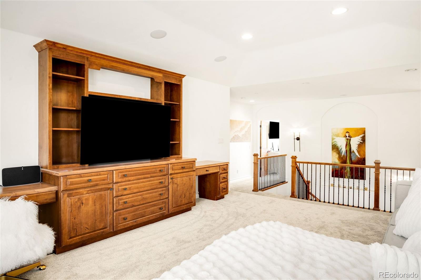 981 Buffalo Ridge Road Castle Pines, CO 80108 - Photo 25 of 49 a bedroom with furniture and flat screen tv
