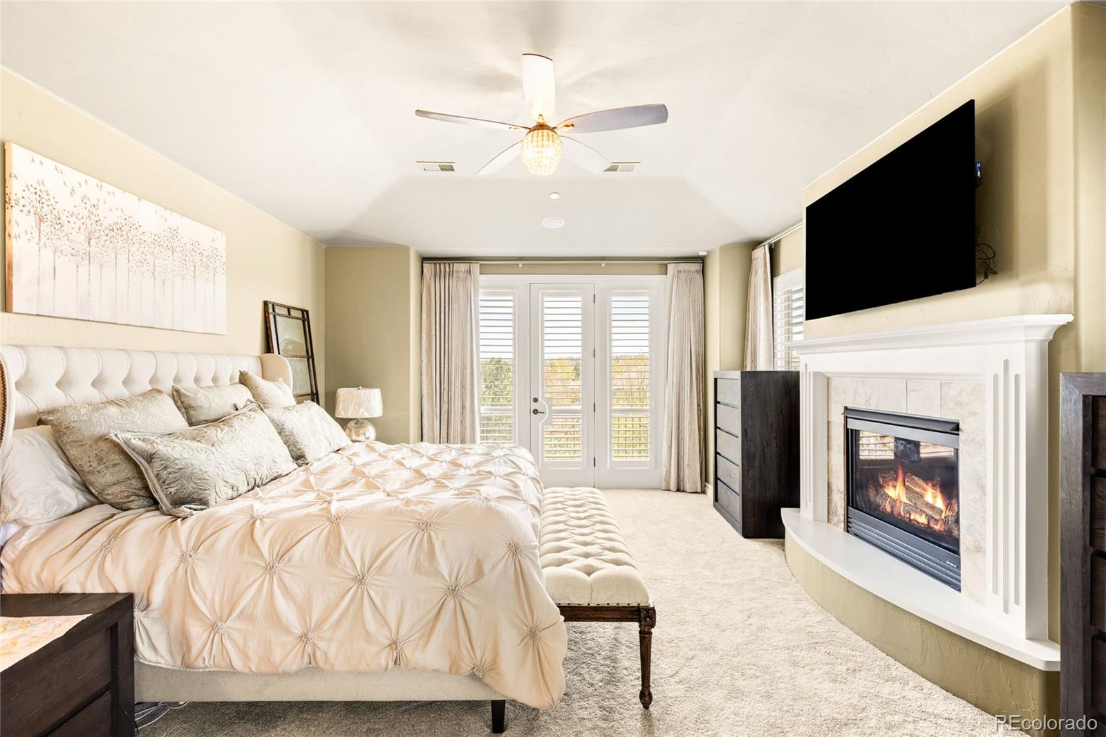 981 Buffalo Ridge Road Castle Pines, CO 80108 - Photo 26 of 49 a bedroom with a bed and a flat screen tv