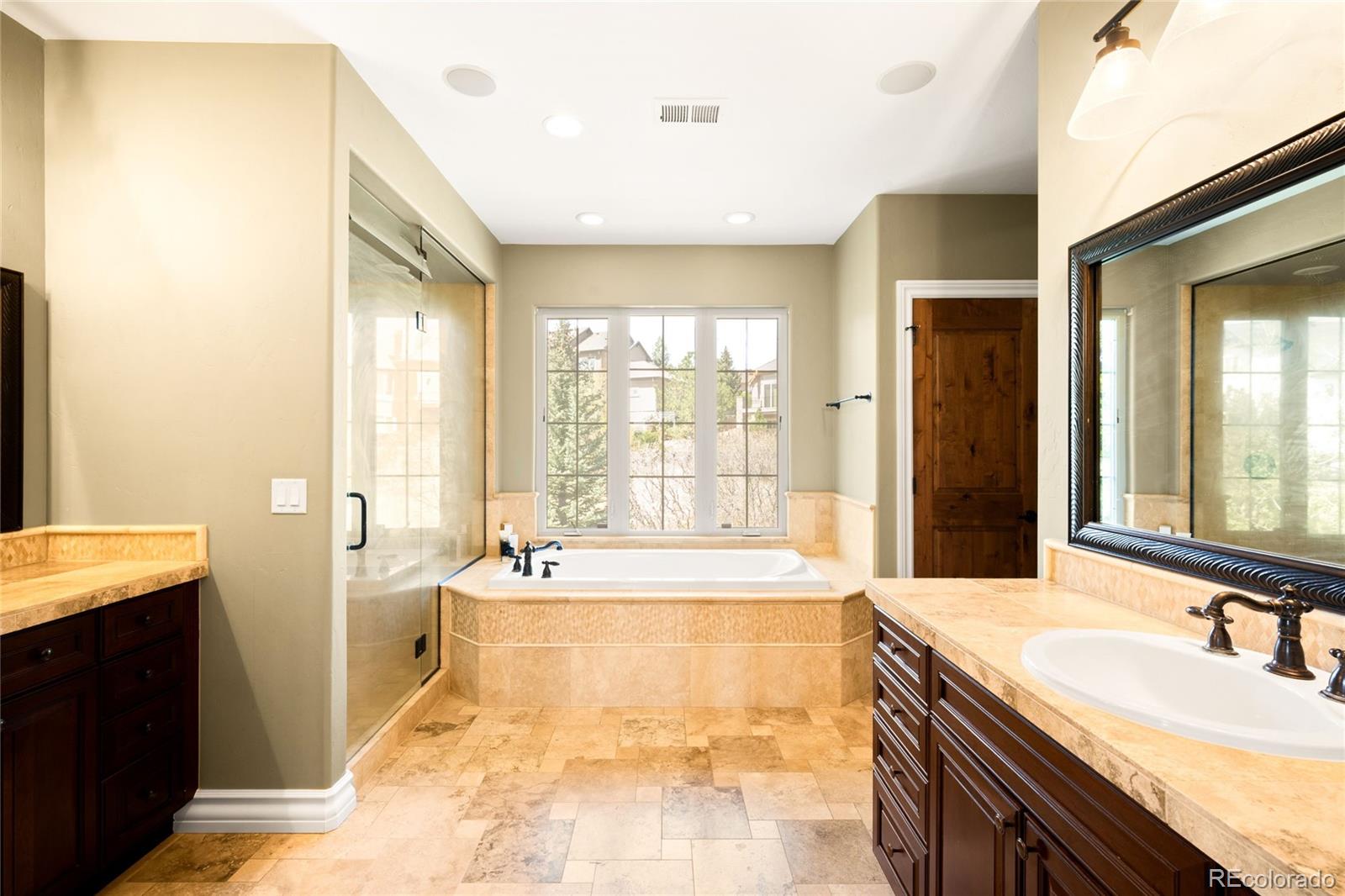 981 Buffalo Ridge Road Castle Pines, CO 80108 - Photo 28 of 49 a spacious bathroom with a tub sink and mirror