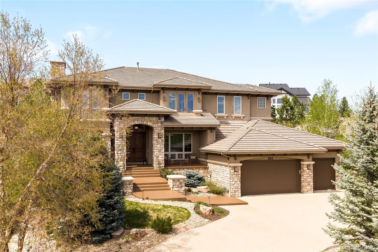 981 Buffalo Ridge Road Castle Pines, CO 80108 - Photo 4 of 49 a front view of a house with yard outdoor seating and barbeque oven