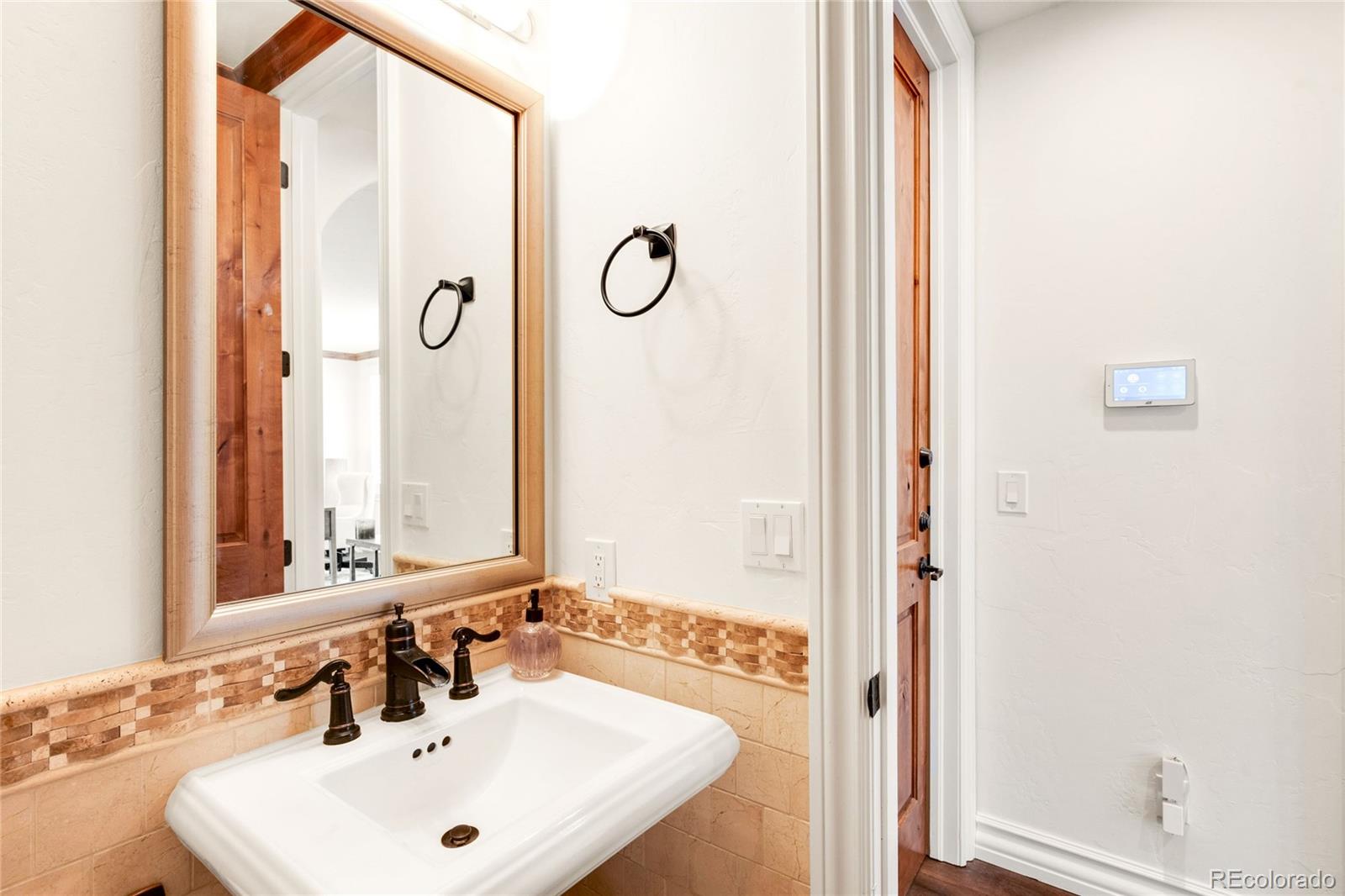 981 Buffalo Ridge Road Castle Pines, CO 80108 - Photo 41 of 49 a bathroom with a sink and a mirror