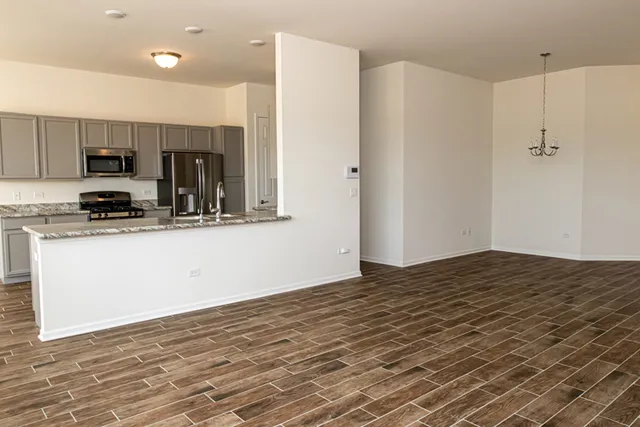 a kitchen with stainless steel appliances granite countertop a refrigerator and a stove top oven