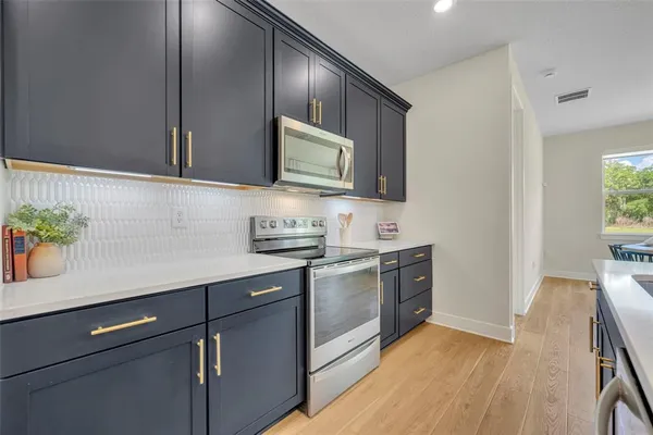 a kitchen with stainless steel appliances granite countertop a sink stove and microwave
