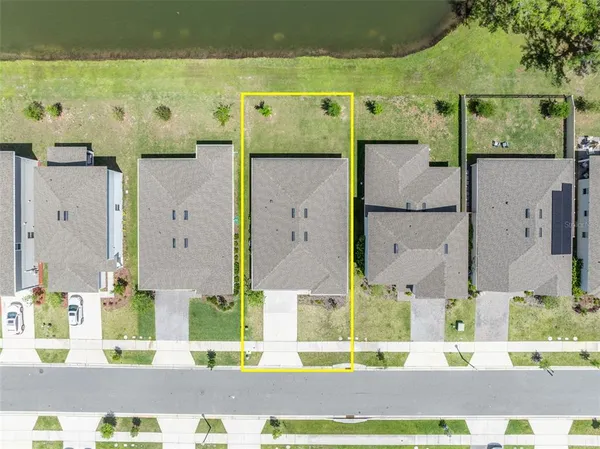an aerial view of residential houses with outdoor space and ocean view