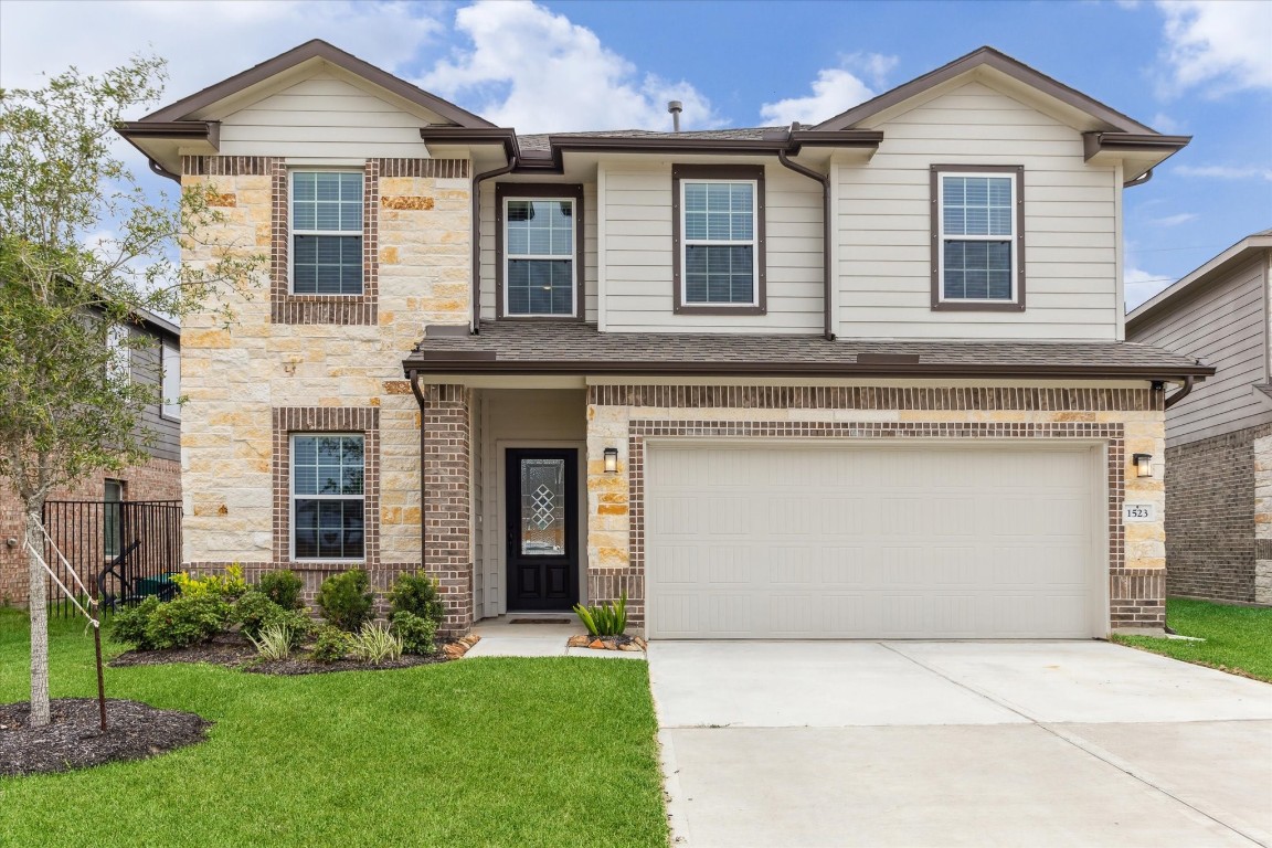 a front view of a house with a yard and garage
