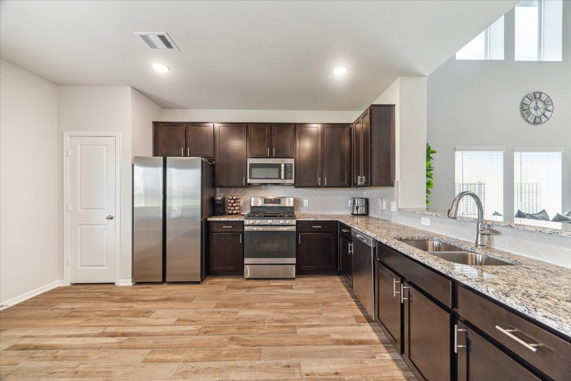1523 Alpine Drive Rosharon, TX 77583 - Photo 10 of 25 a kitchen with stainless steel appliances granite countertop a sink stove and refrigerator