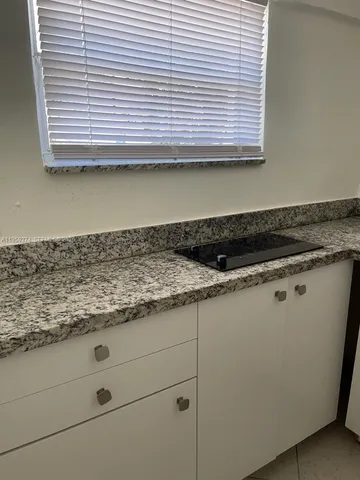 a view of kitchen cabinets and window