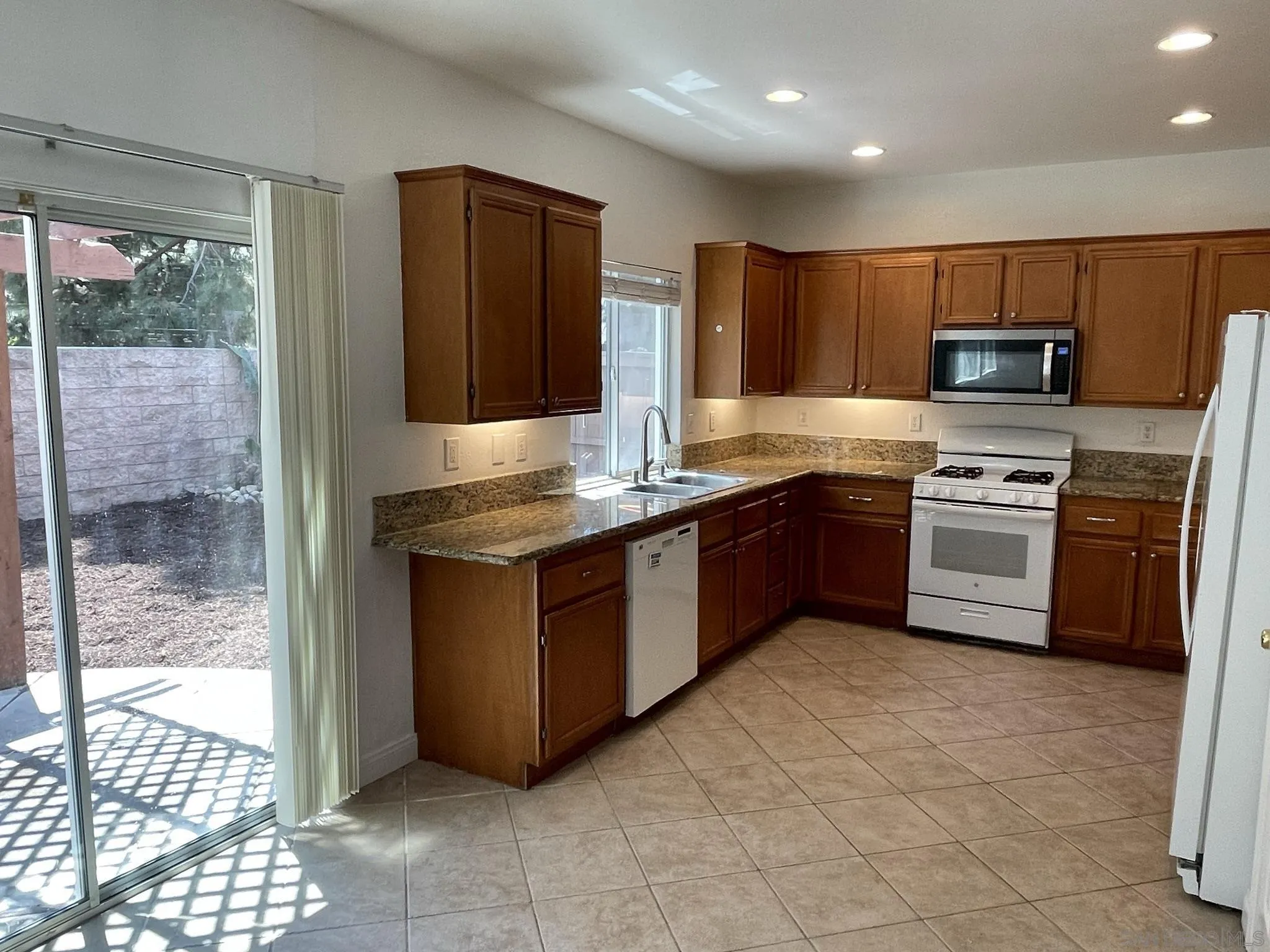 348 Monte Vista Way Oceanside, CA 92057 - Photo 4 of 20 a kitchen with stainless steel appliances granite countertop a stove a sink and a refrigerator