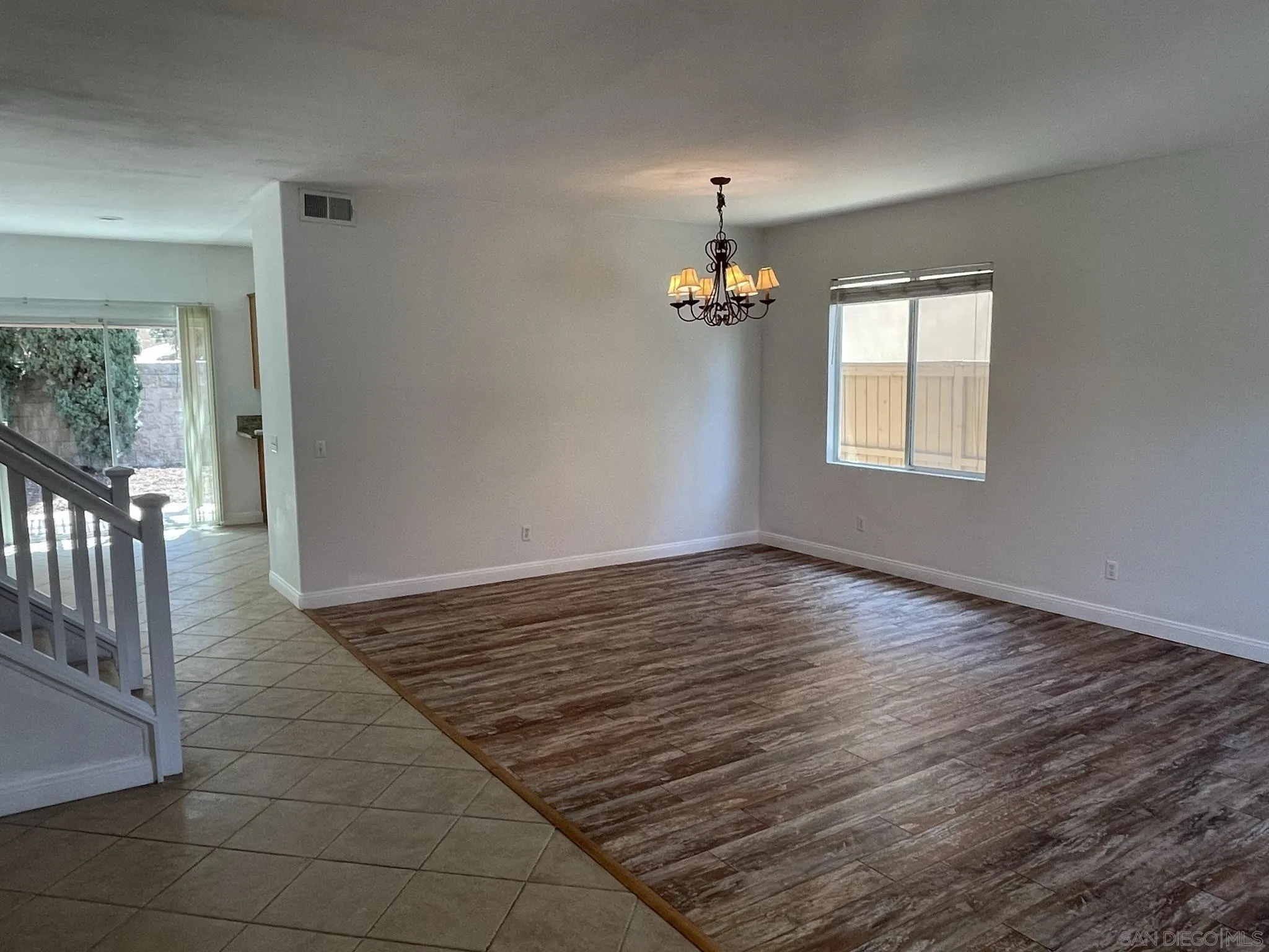 348 Monte Vista Way Oceanside, CA 92057 - Photo 8 of 20 an empty room with wooden floor and chandelier