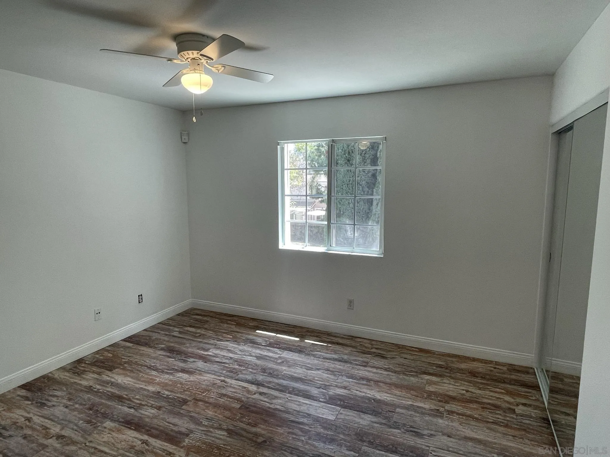 348 Monte Vista Way Oceanside, CA 92057 - Photo 10 of 20 an empty room with wooden floor fan and windows