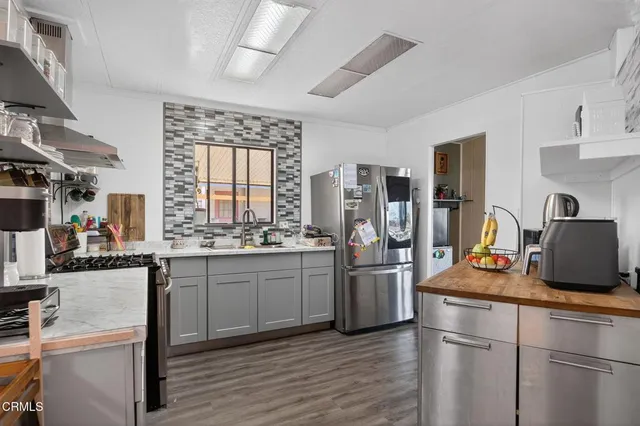a kitchen with stainless steel appliances granite countertop a refrigerator and a stove top oven