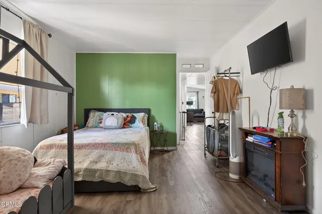a bedroom with furniture and a flat screen tv