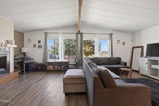 a living room with furniture flat screen tv and a large window