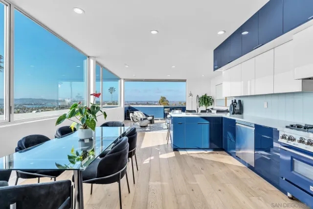 a kitchen with stainless steel appliances kitchen island granite countertop a table chairs in it and wooden floors