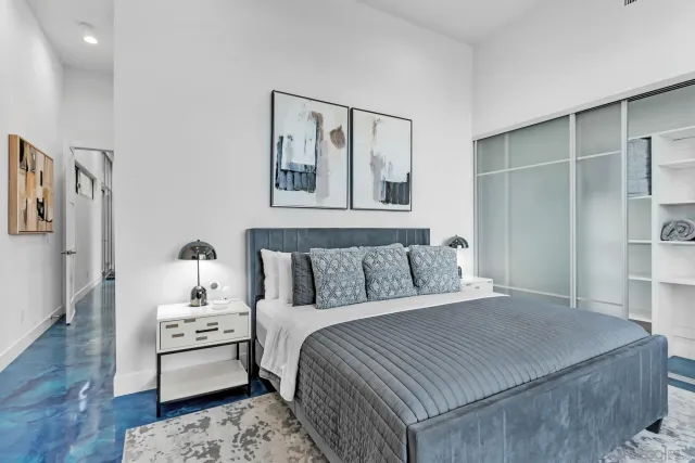 a bedroom with a large bed and a large mirror