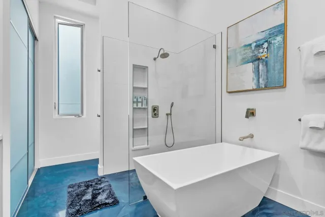 a spacious bathroom with a tub sink and mirror