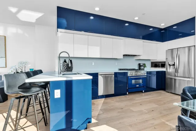 a kitchen with stainless steel appliances kitchen island granite countertop a sink refrigerator and cabinets