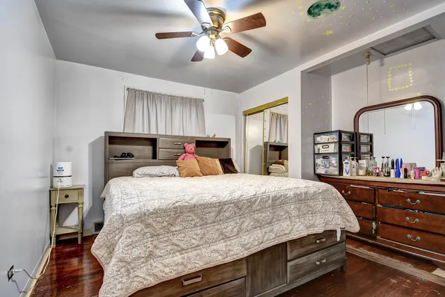 a bedroom with a bed and dresser with mirror
